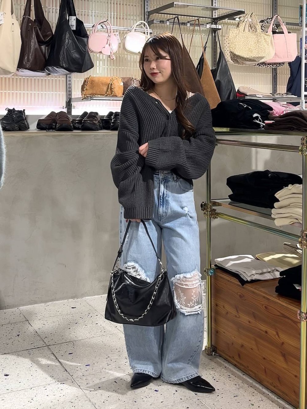 ホワイト系のキャミソール、ブラック系のパンプス、ブルー系のデニムパンツを着用したレディースの冬コーディネートの3枚目の写真