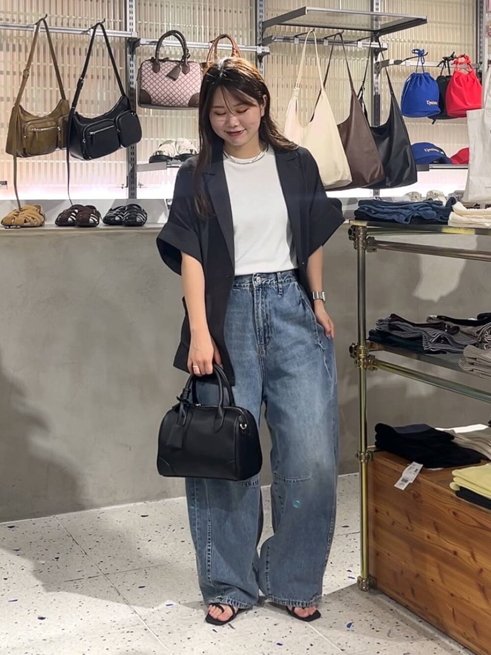 ホワイト系のTシャツ/カットソー、ブルー系のデニムパンツ、ブラック系のサンダルを着用したレディースの夏コーディネートの2枚目の写真