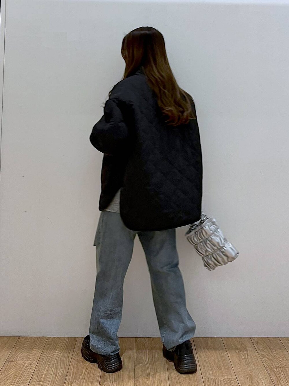 ブラック系のブルゾン、ブルー系のデニムパンツ、ブラック系のスニーカーを着用したレディースの冬コーディネートの4枚目の写真