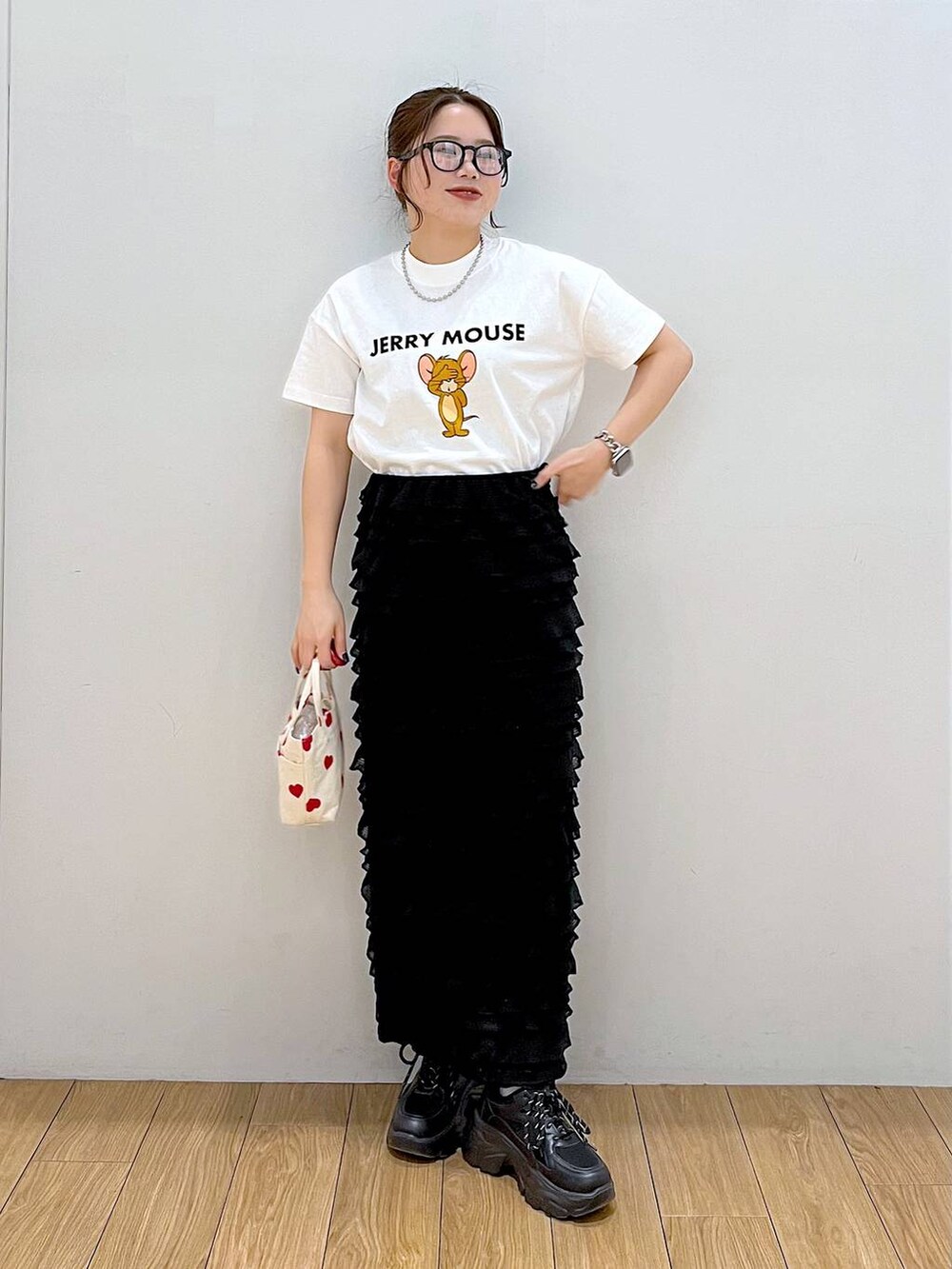 ブラック系のスカート、ホワイト系のTシャツ/カットソー、レッド系のショルダーバッグを着用したレディースの春コーディネートの4枚目の写真