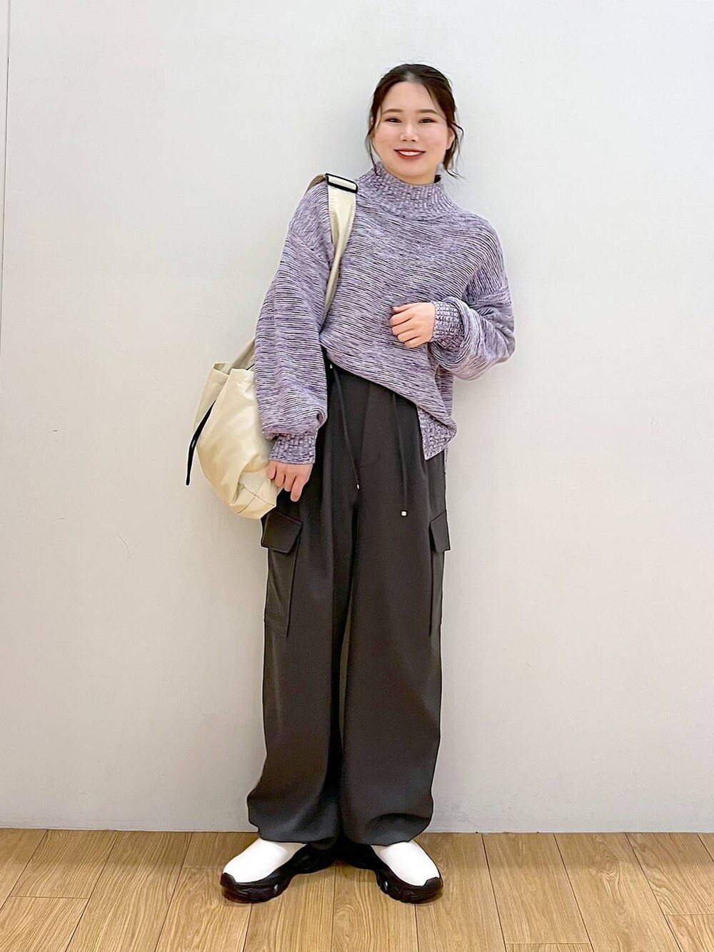 パープル系のニット/セーター、グレー系のカーゴパンツ、ホワイト系のブーツを着用したレディースの冬コーディネートの2枚目の写真
