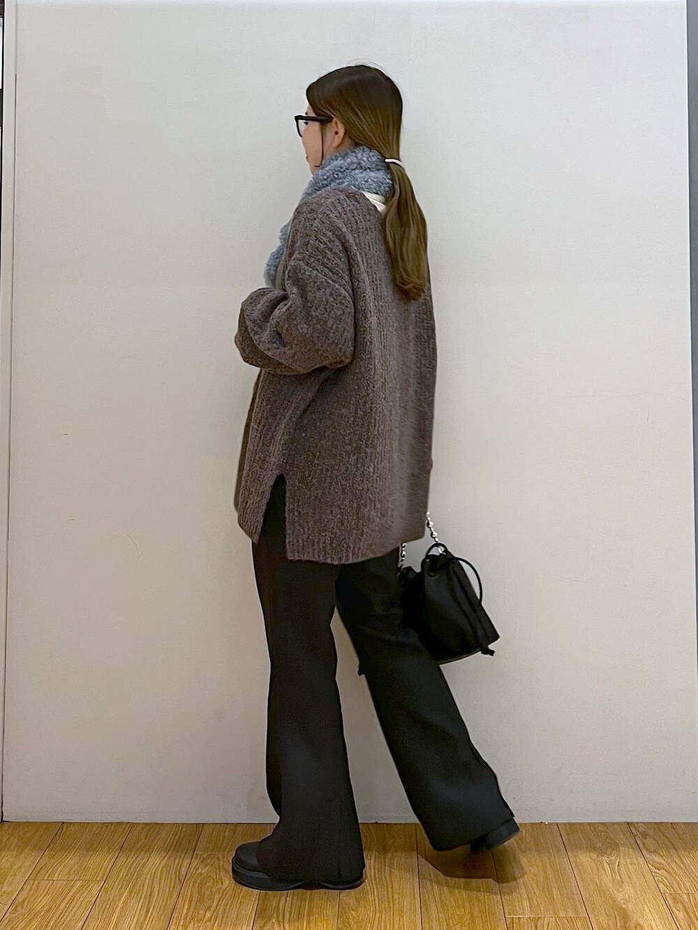 ブラック系のブーツ、ブラック系のスラックス、ブラック系のショルダーバッグを着用したレディースの冬コーディネートの5枚目の写真