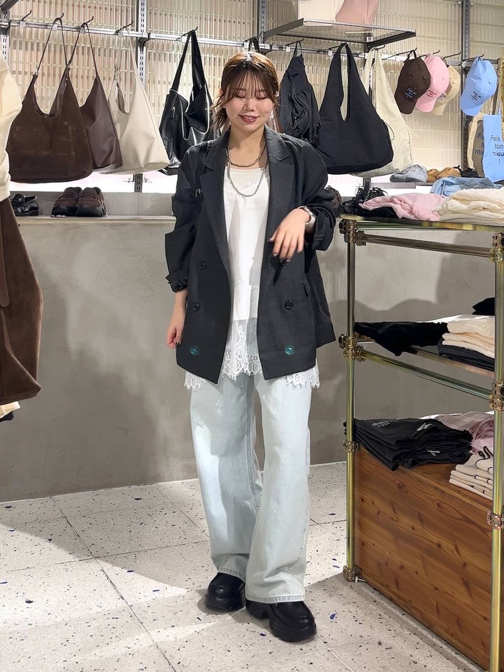 グレー系のテーラードジャケット、ブルー系のデニムパンツ、ブラック系のショルダーバッグを着用したレディースの春コーディネートの4枚目の写真
