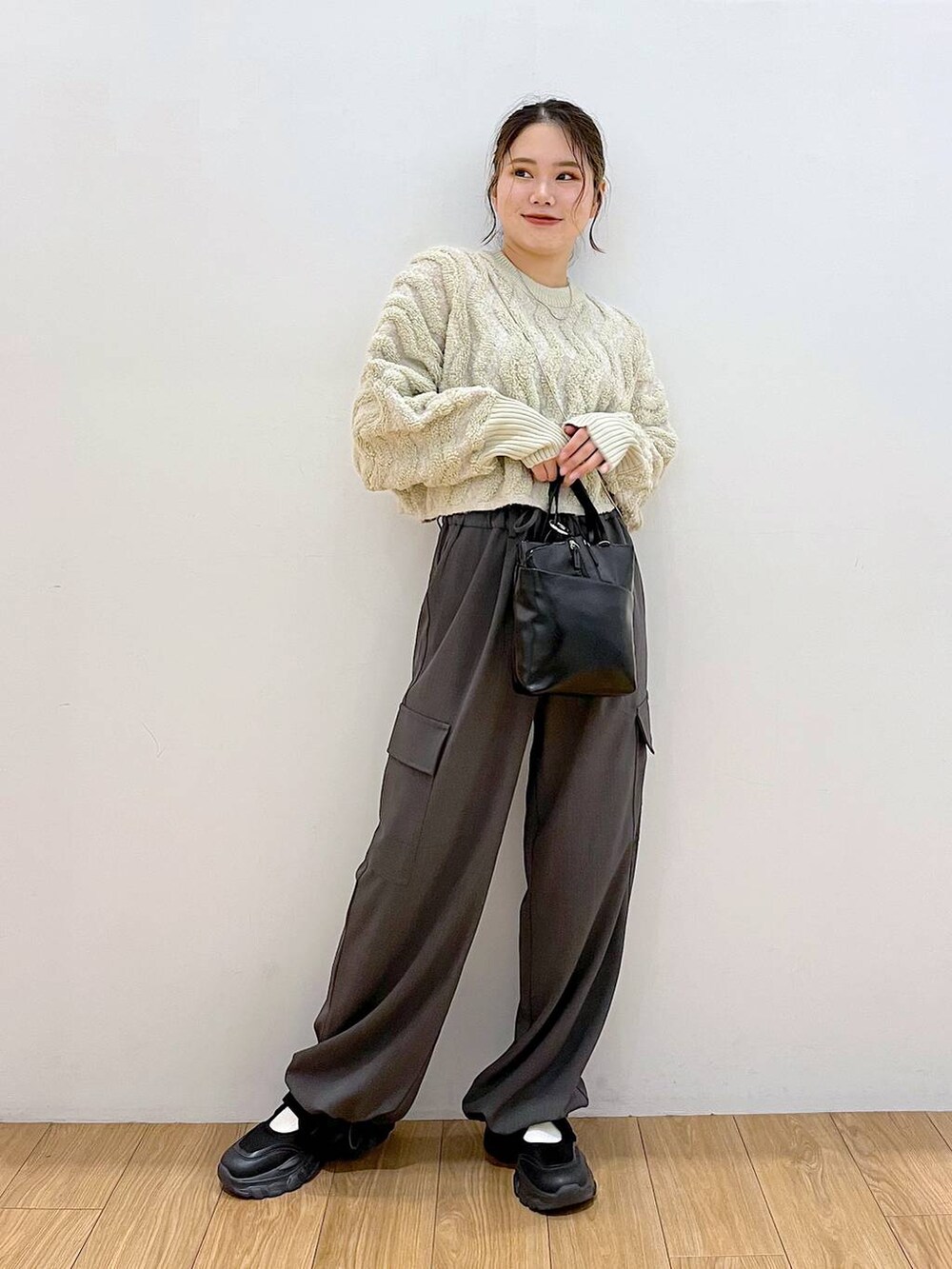 ブラック系のショルダーバッグ、グレー系のその他パンツ、ホワイト系のニット/セーターを着用したレディースの秋コーディネートの3枚目の写真