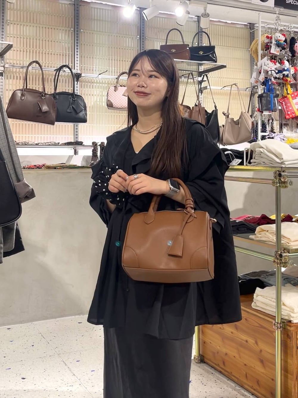 ブラック系のスカート、ブラウン系のショルダーバッグ、ブラック系のパンプスを着用したレディースの秋コーディネートの2枚目の写真