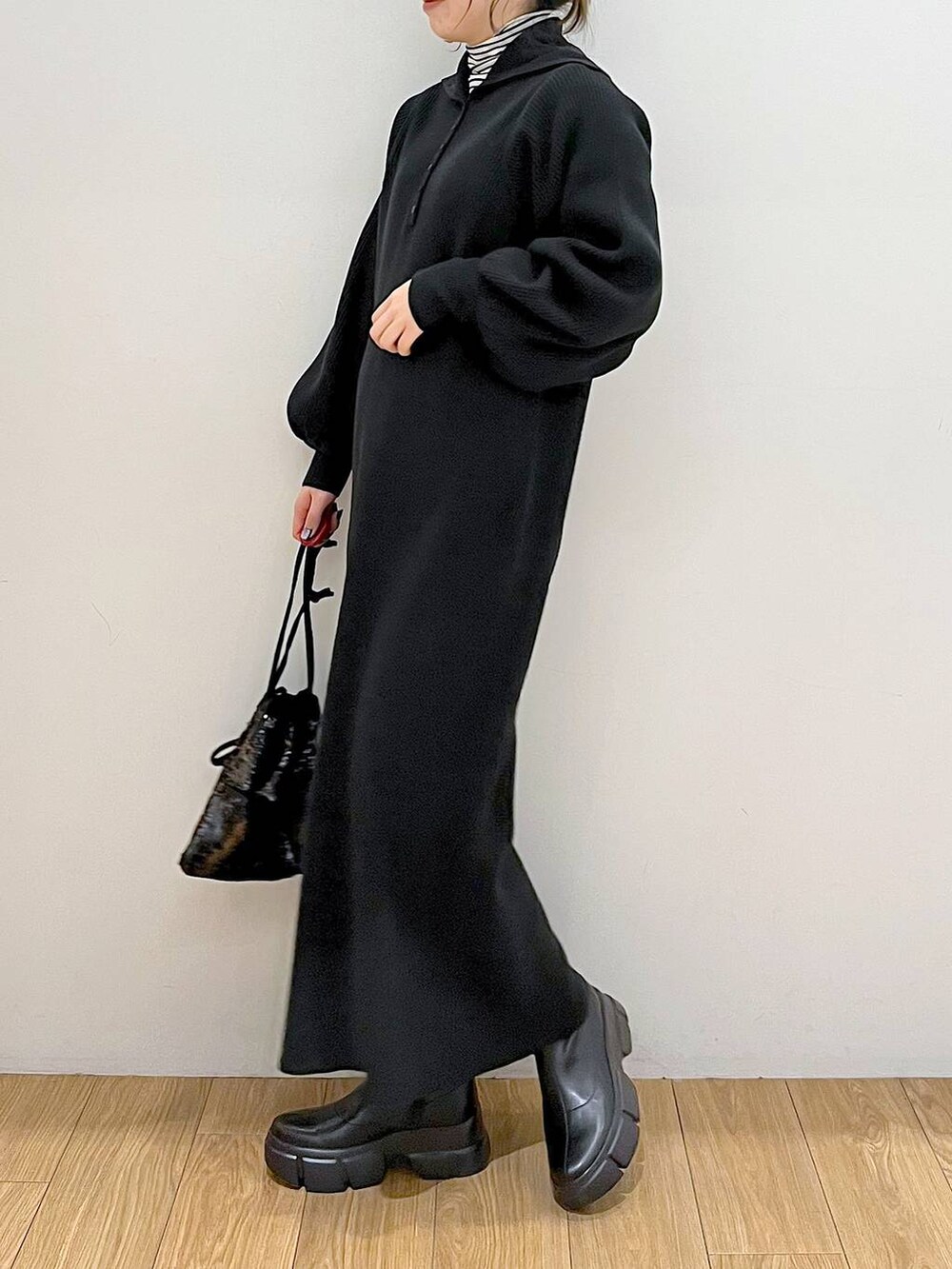 ホワイト系のTシャツ/カットソー、ブラック系のブーツ、ブラック系のハンドバッグを着用したレディースの冬コーディネートの4枚目の写真