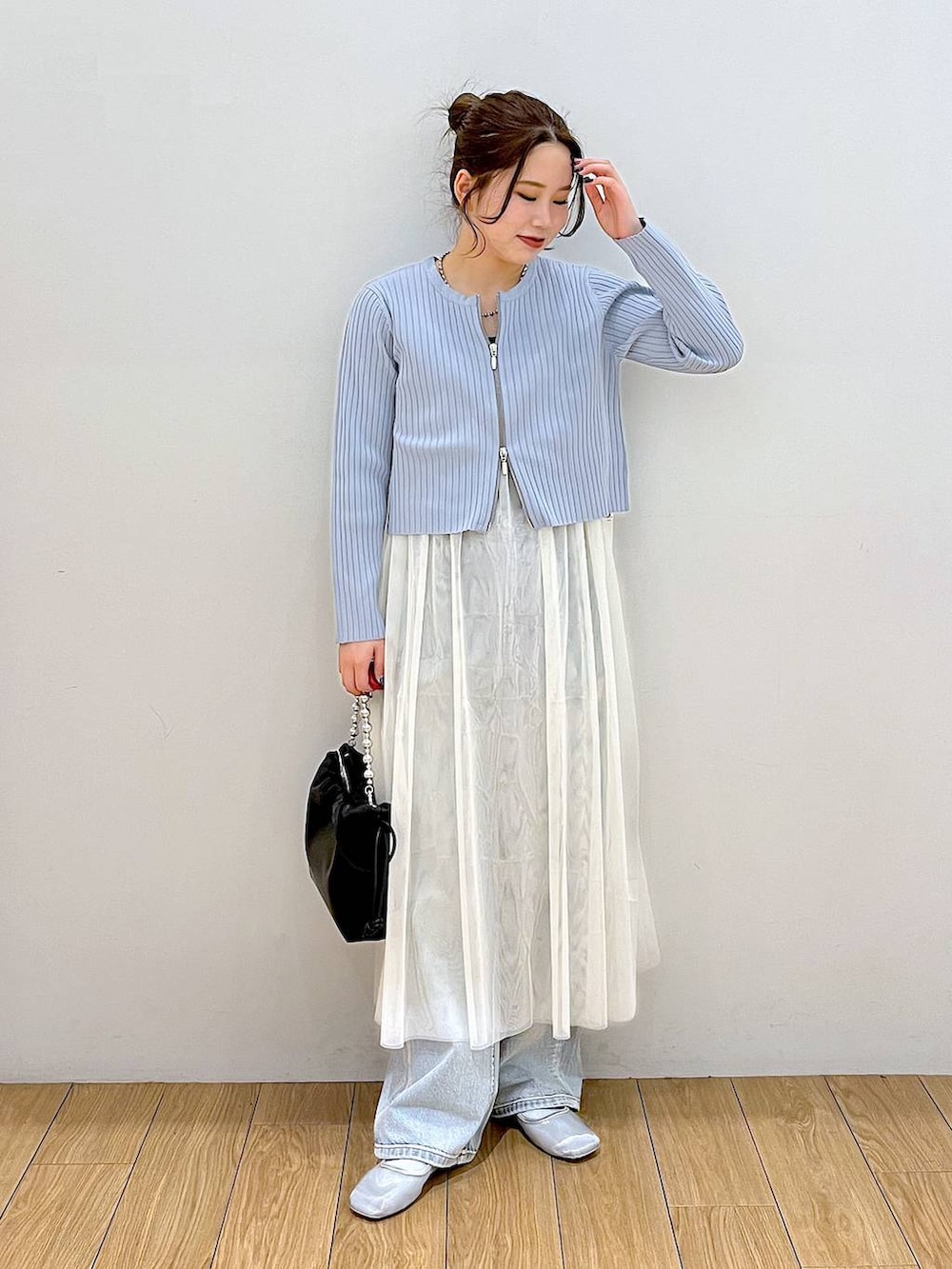 ブラック系のショルダーバッグ、ブルー系のデニムパンツ、ホワイト系のワンピースを着用したレディースの春コーディネートの4枚目の写真