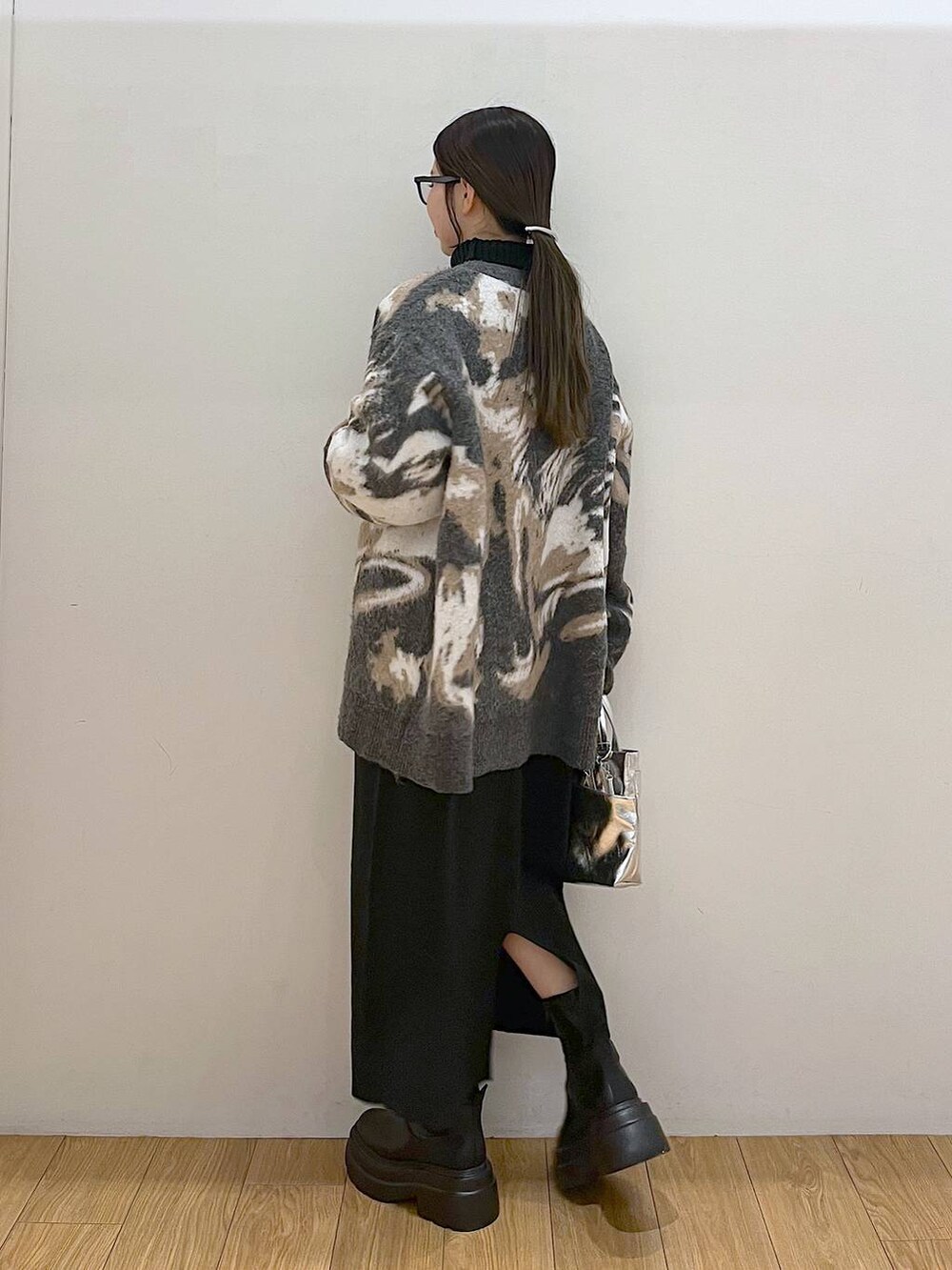 シルバー系のショルダーバッグ、ブラック系のワンピース、グレー系のカーディガン/ボレロを着用したレディースの冬コーディネートの5枚目の写真