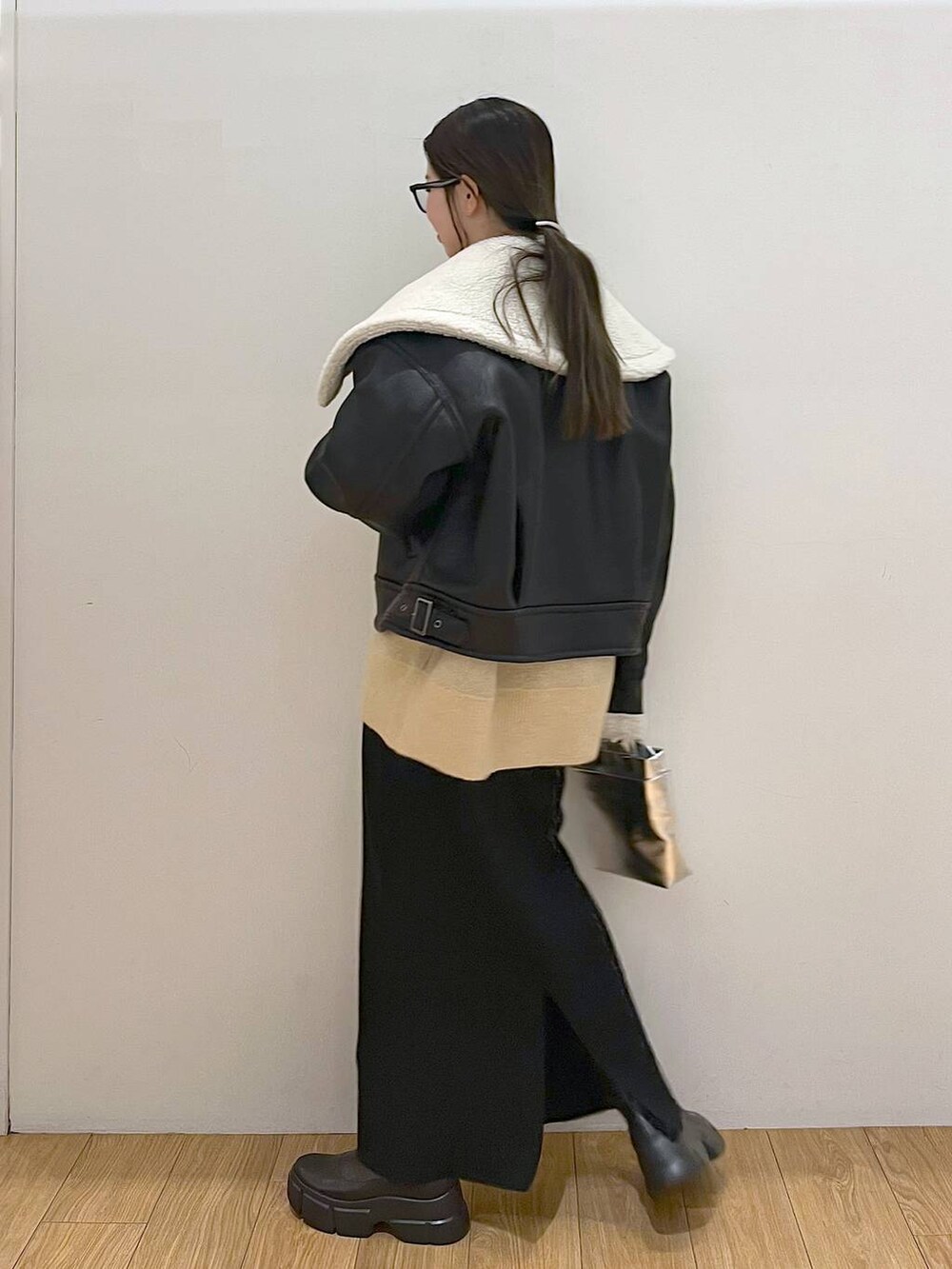 シルバー系のショルダーバッグ、ブラック系のブルゾン、ブラック系のスカートを着用したレディースの冬コーディネートの5枚目の写真