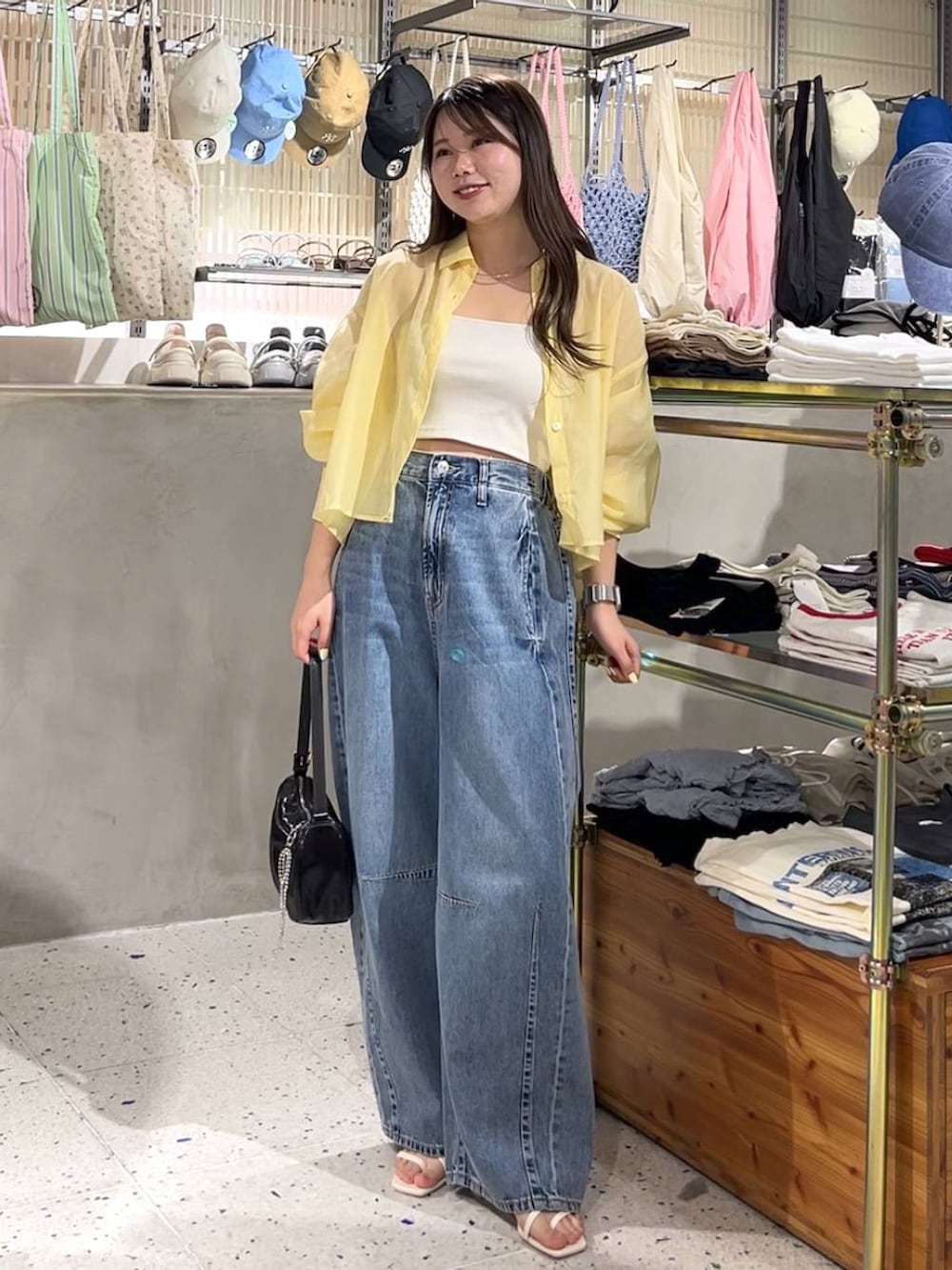 ホワイト系のキャミソール、イエロー系のシャツ/ブラウス、ブラック系のトートバッグを着用したレディースの春コーディネートの3枚目の写真