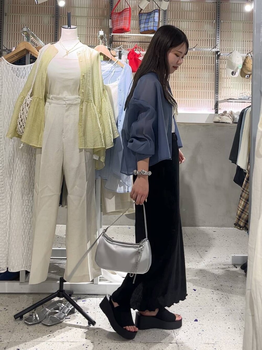 ブルー系のシャツ/ブラウス、ブラック系のサンダル、シルバー系のトートバッグを着用したレディースの春コーディネートの4枚目の写真