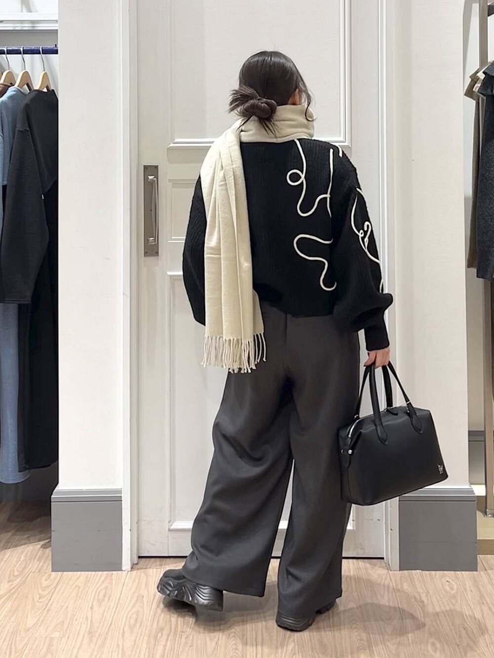 ブラック系のショルダーバッグ、ブラック系のニット/セーター、グレー系のその他パンツを着用したレディースの冬コーディネートの3枚目の写真