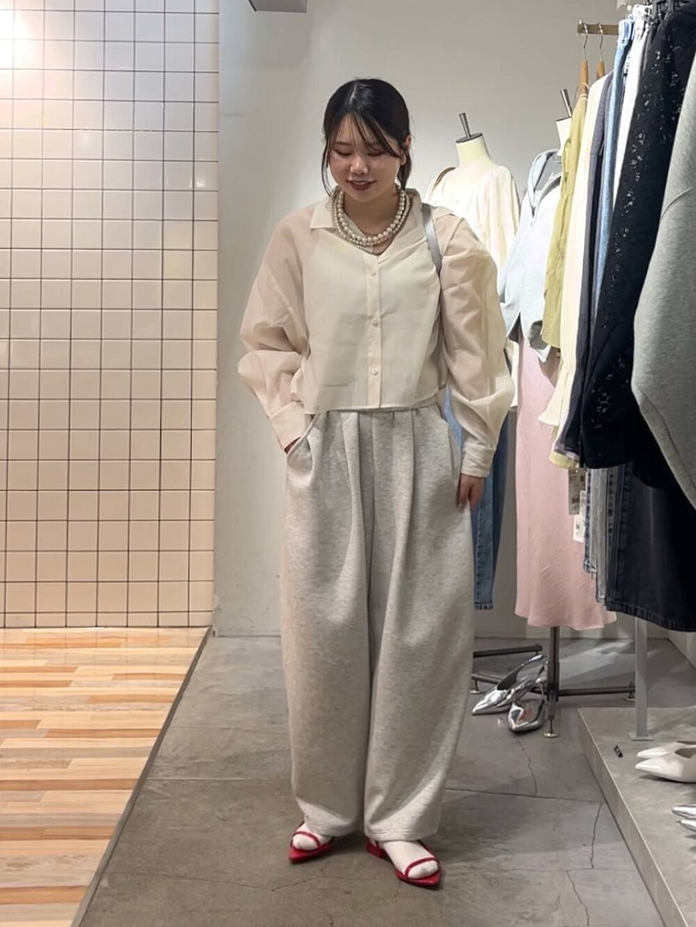 ホワイト系のシャツ/ブラウス、シルバー系のトートバッグ、グレー系のスウェットパンツを着用したレディースの春コーディネートの2枚目の写真