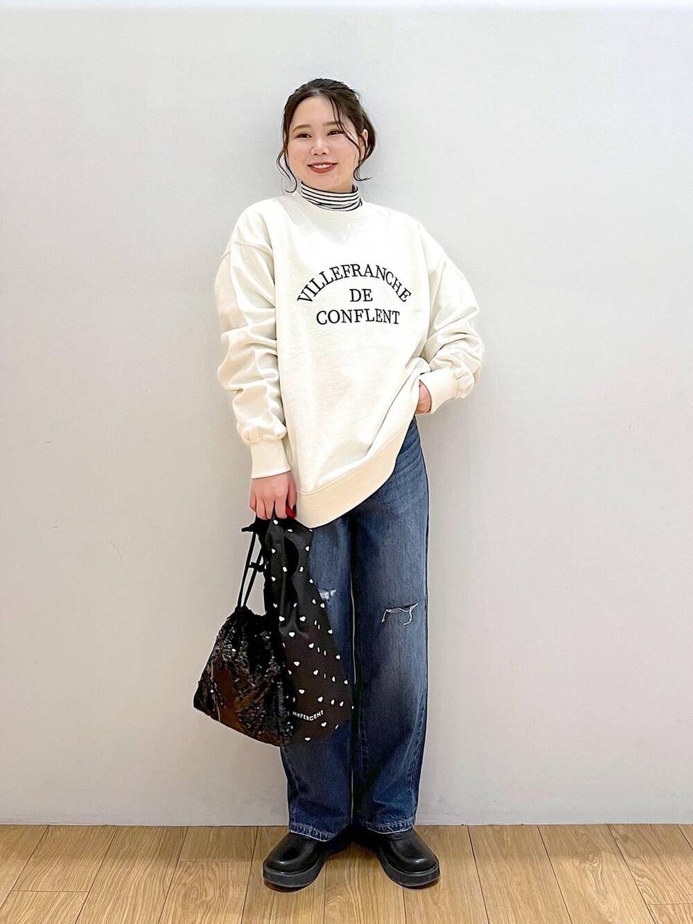 ホワイト系のTシャツ/カットソー、ブルー系のデニムパンツ、ブラック系のブーツを着用したレディースの冬コーディネートの3枚目の写真