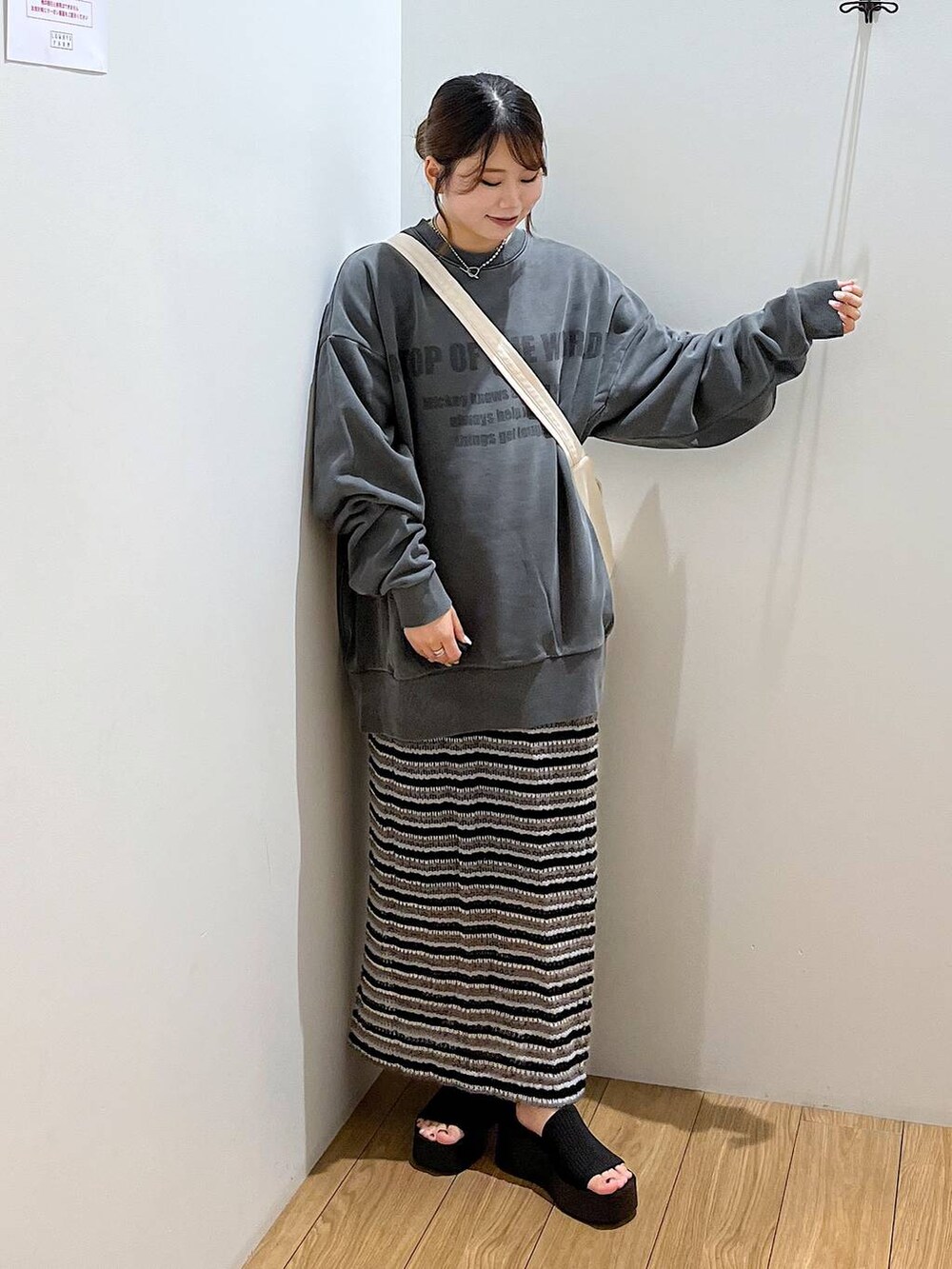 ブラック系のサンダル、ホワイト系のショルダーバッグ、ブラック系のスカートを着用したレディースの夏コーディネートの3枚目の写真