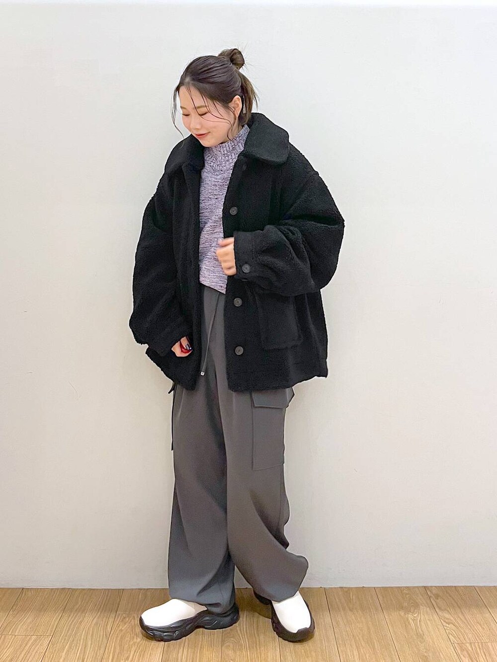 パープル系のニット/セーター、ブラック系のブルゾン、ホワイト系のブーツを着用したレディースの冬コーディネートの3枚目の写真