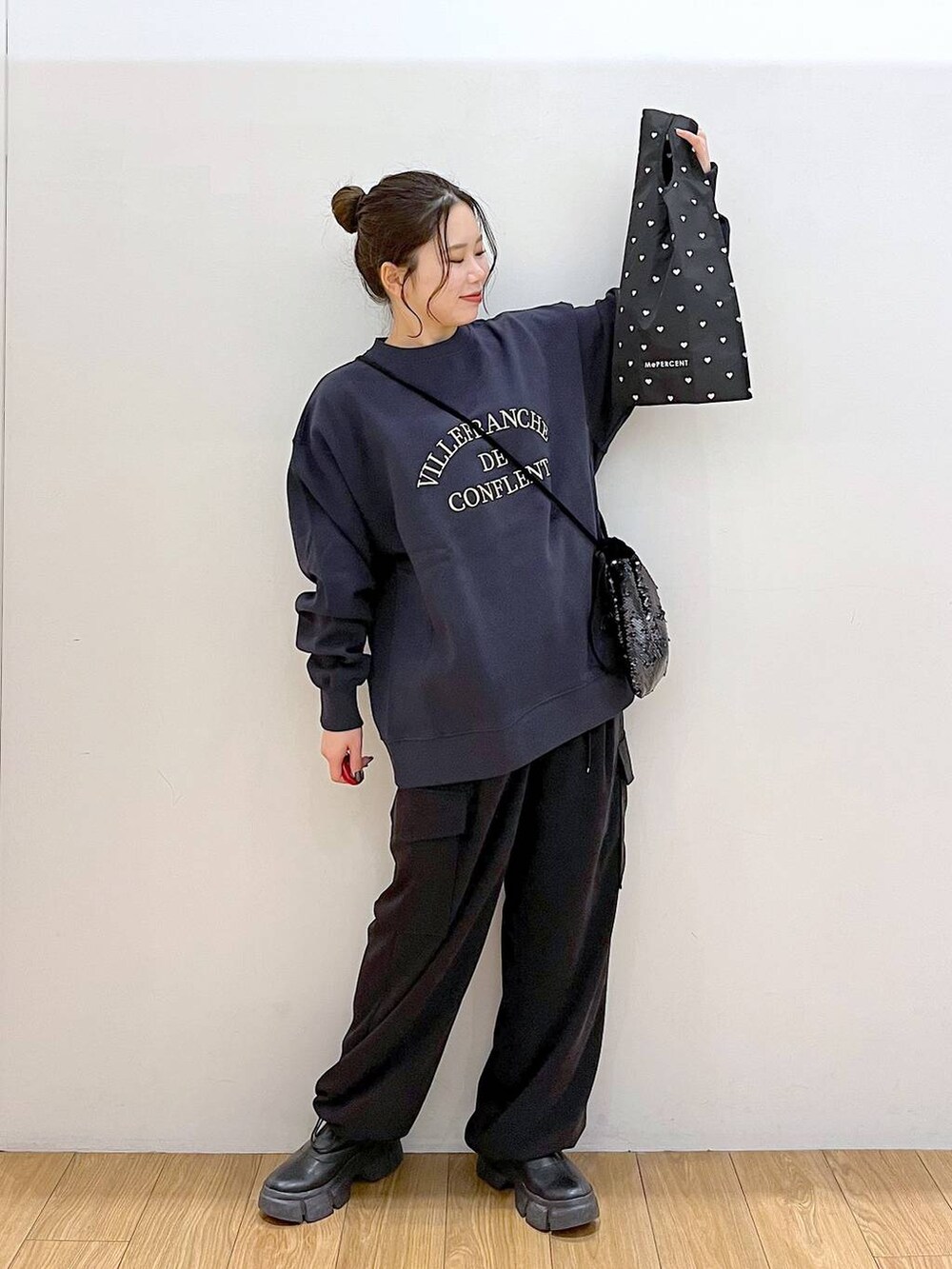 ブラック系のブーツ、ブラック系のハンドバッグ、ブラック系のカーゴパンツを着用したレディースの冬コーディネートの3枚目の写真