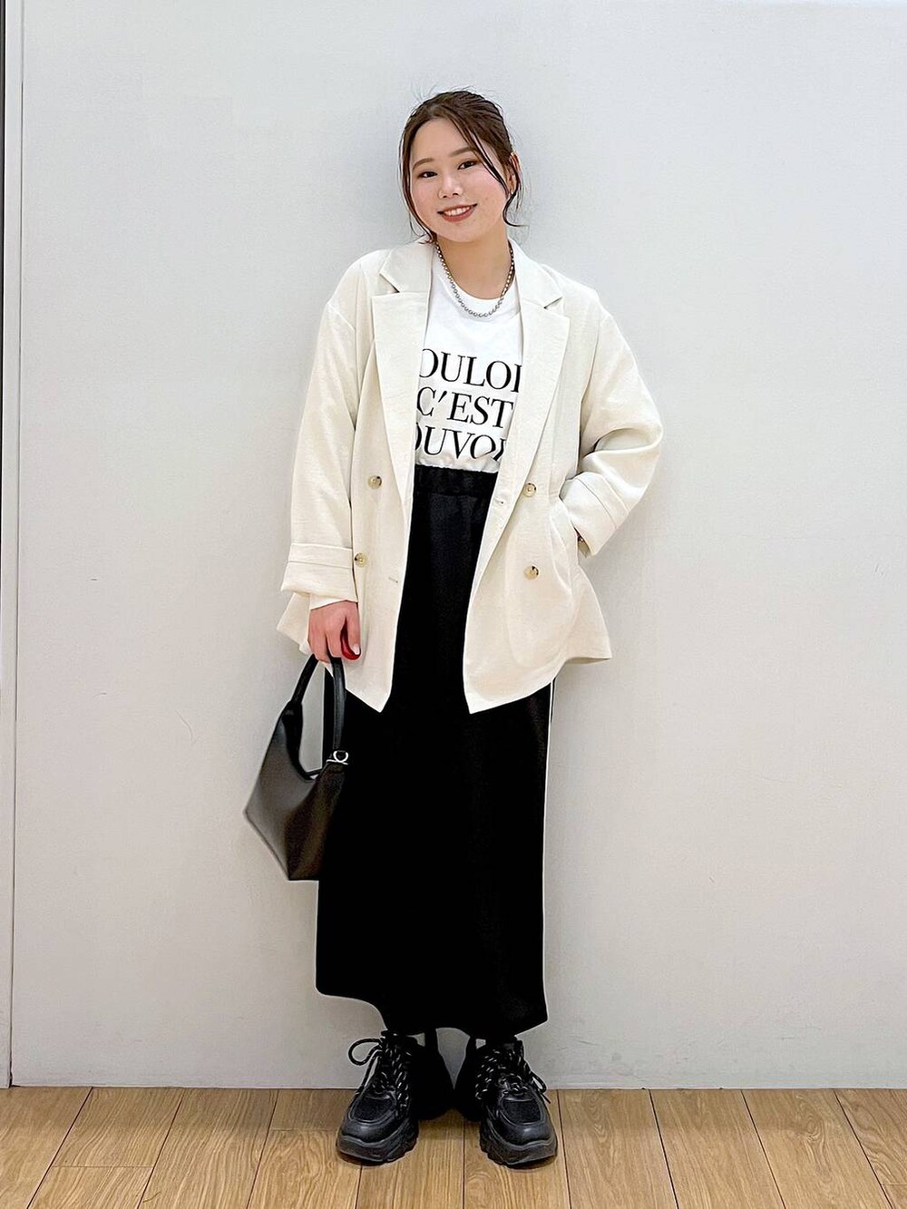 ホワイト系のテーラードジャケット、ホワイト系のTシャツ/カットソー、ブラック系のスニーカーを着用したレディースの春コーディネートの3枚目の写真