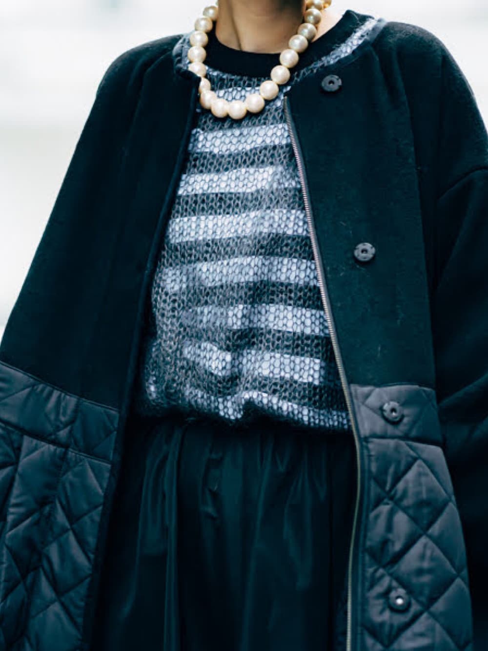 グレー系のニット/セーター、ブラック系のその他アウター、ブラック系のブーツを着用したレディースの秋コーディネートの3枚目の写真