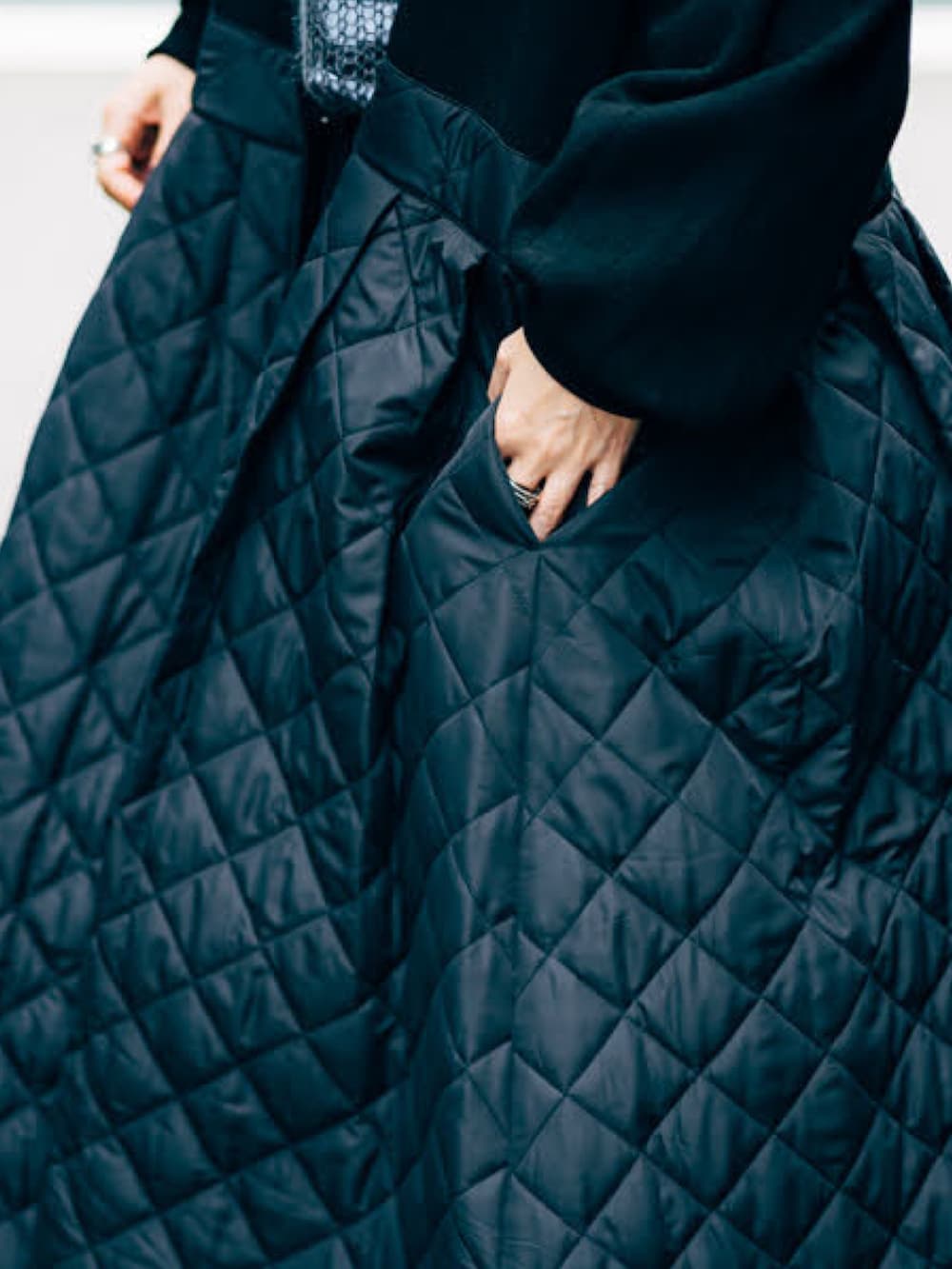 グレー系のニット/セーター、ブラック系のその他アウター、ブラック系のブーツを着用したレディースの秋コーディネートの4枚目の写真