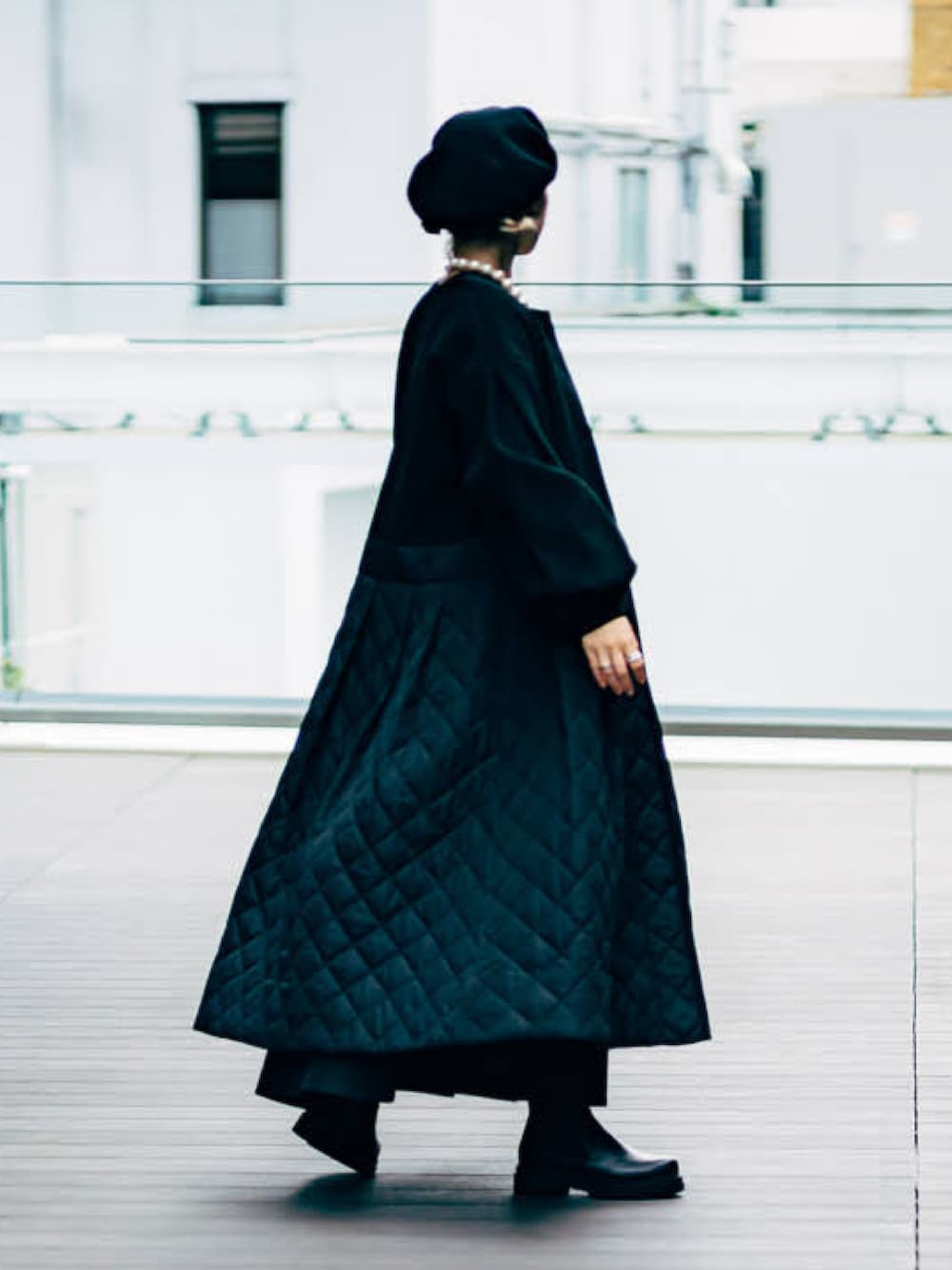 グレー系のニット/セーター、ブラック系のその他アウター、ブラック系のブーツを着用したレディースの秋コーディネートの2枚目の写真