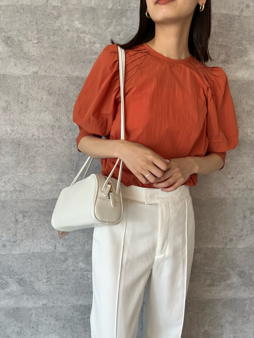 オレンジ系のシャツ/ブラウス、ホワイト系のその他パンツ、ホワイト系のバッグを着用したレディースの夏コーディネートの2枚目の写真