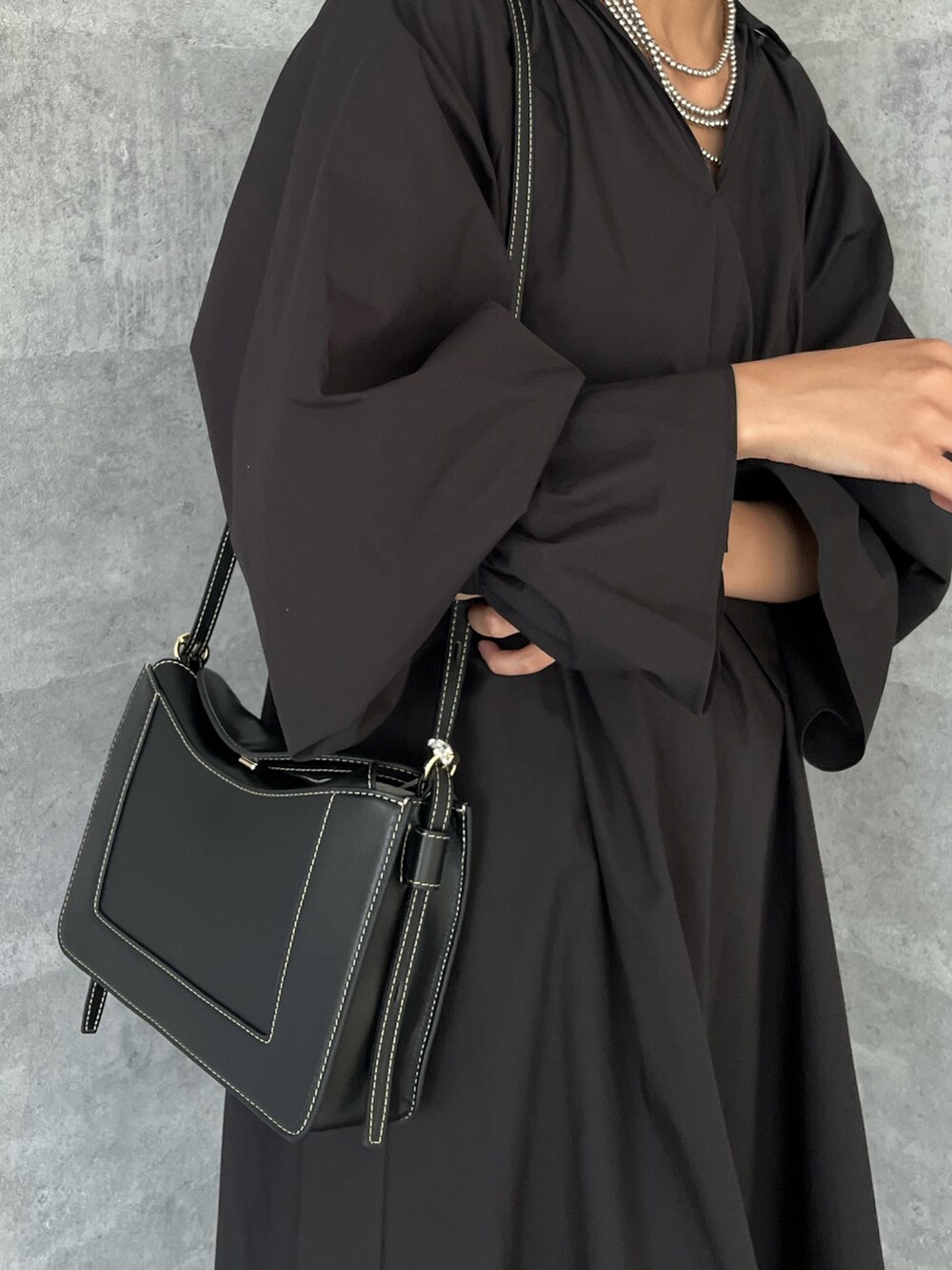ブラック系のワンピース、イエロー系のその他パンツ、ブラック系のショルダーバッグを着用したレディースの夏コーディネートの2枚目の写真
