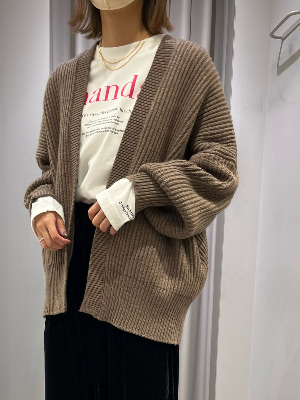 ホワイト系のブルゾン、ブラウン系のカーディガン/ボレロ、ブラック系のその他パンツを着用したレディースの秋コーディネートの2枚目の写真