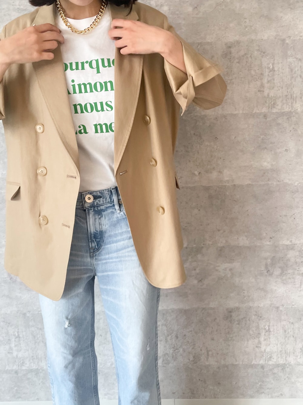 グリーン系のTシャツ/カットソー、ベージュ系のテーラードジャケット、ブルー系のパンツを着用したレディースの春コーディネートの2枚目の写真