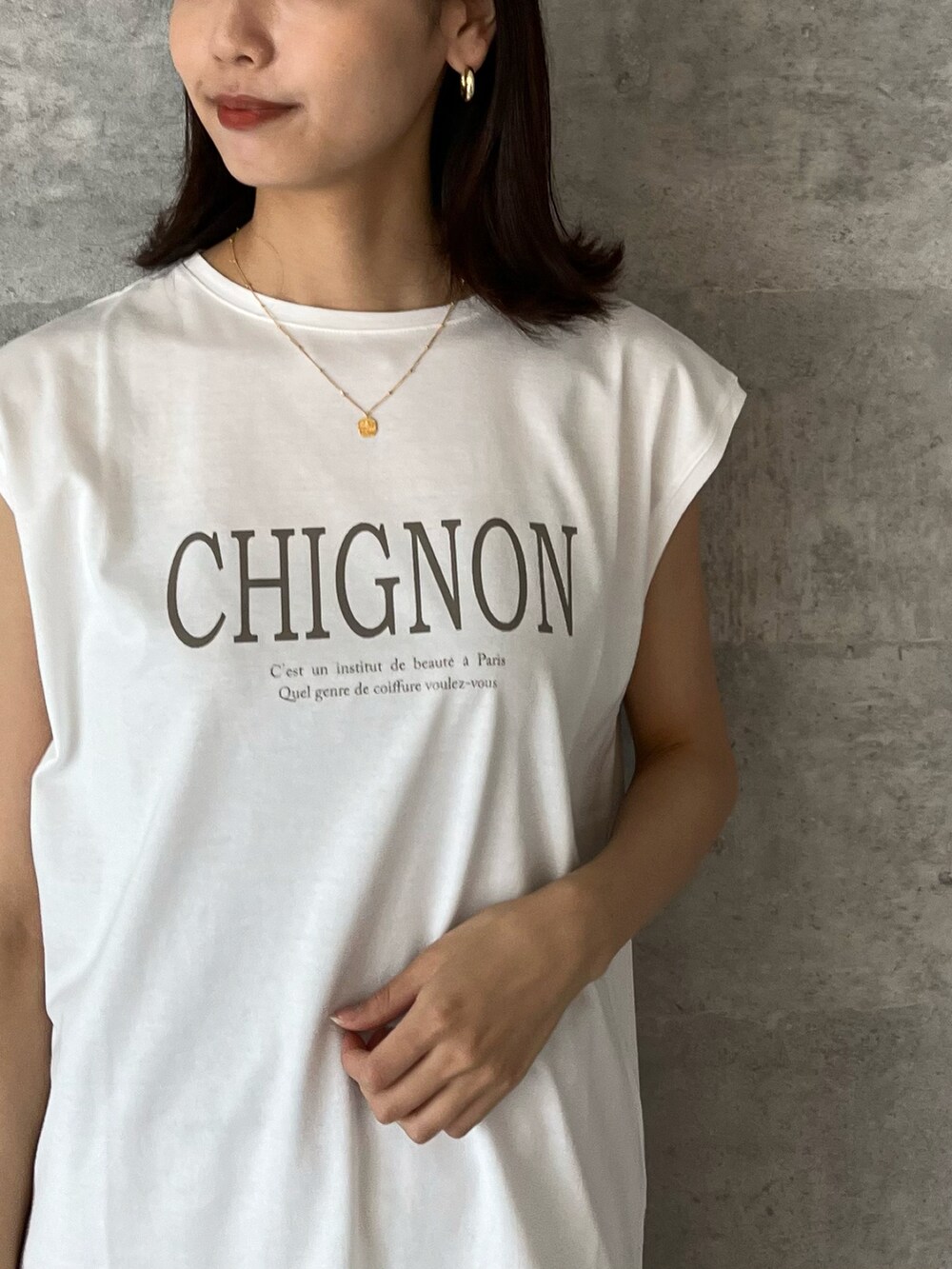 ブラウン系のTシャツ/カットソー、ベージュ系のスカート、シルバー系のサンダルを着用したレディースの春コーディネートの2枚目の写真