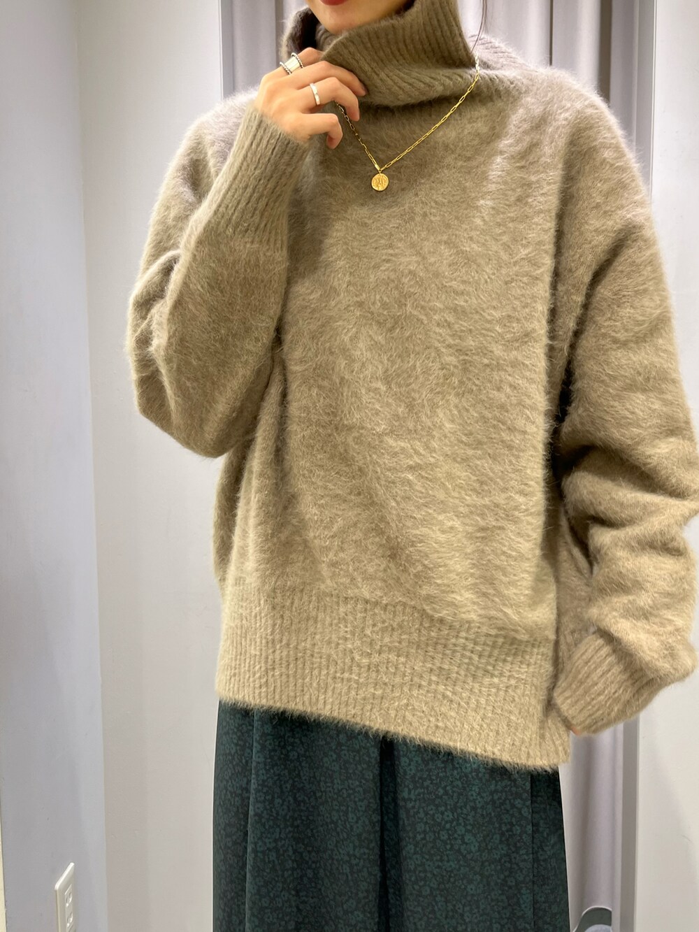 ホワイト系のその他アウター、グリーン系のスカート、ブラウン系のブーツを着用したレディースの秋コーディネートの2枚目の写真