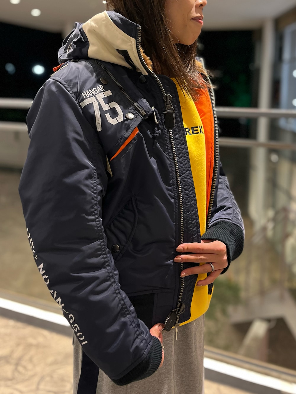 イエロー系のスウェット、グレー系のスカート、ブルー系のMA-1を着用したレディースの秋コーディネートの3枚目の写真