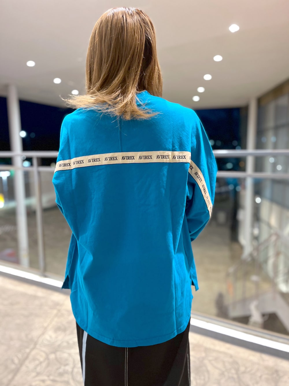 グリーン系のTシャツ/カットソー、ブラック系のスカート、グレー系のショルダーバッグを着用したレディースの冬コーディネートの3枚目の写真