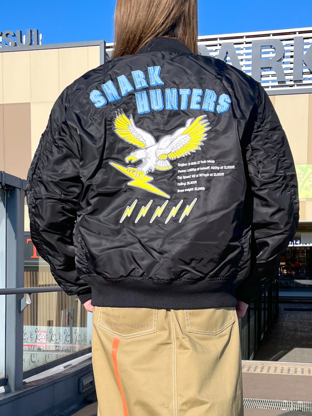 ベージュ系のスウェット、ブラック系のMA-1、ブラウン系のスカートを着用したレディースの冬コーディネートの3枚目の写真