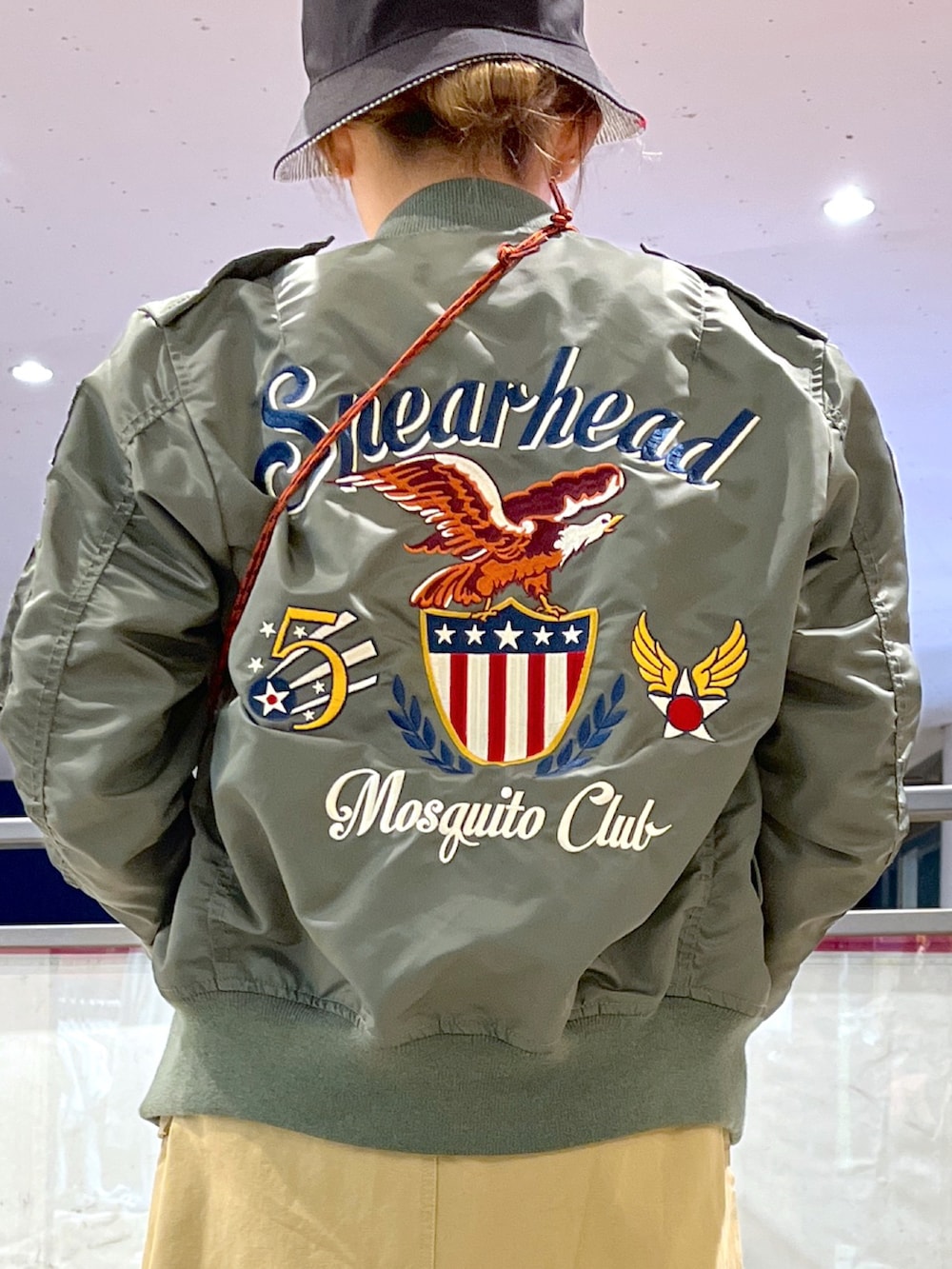 ブラック系のショルダーバッグ、ベージュ系のオールインワン・サロペット、グリーン系のTシャツ/カットソーを着用したレディースの春コーディネートの3枚目の写真