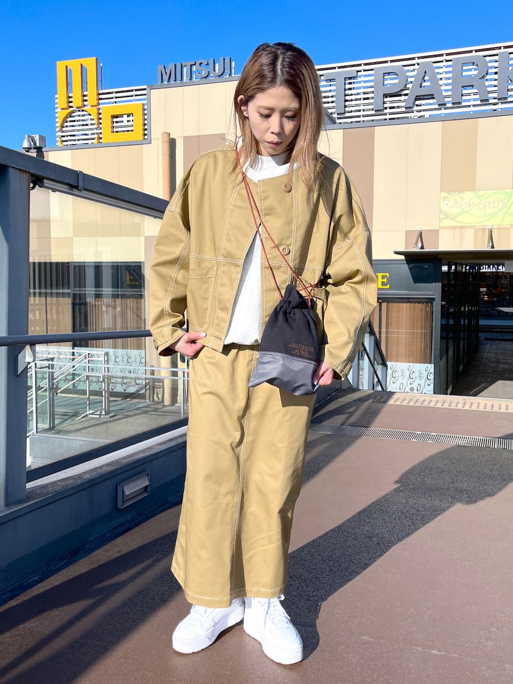 ベージュ系のスウェット、ブラウン系のブルゾン、ブラウン系のスカートを着用したレディースの冬コーディネートの2枚目の写真