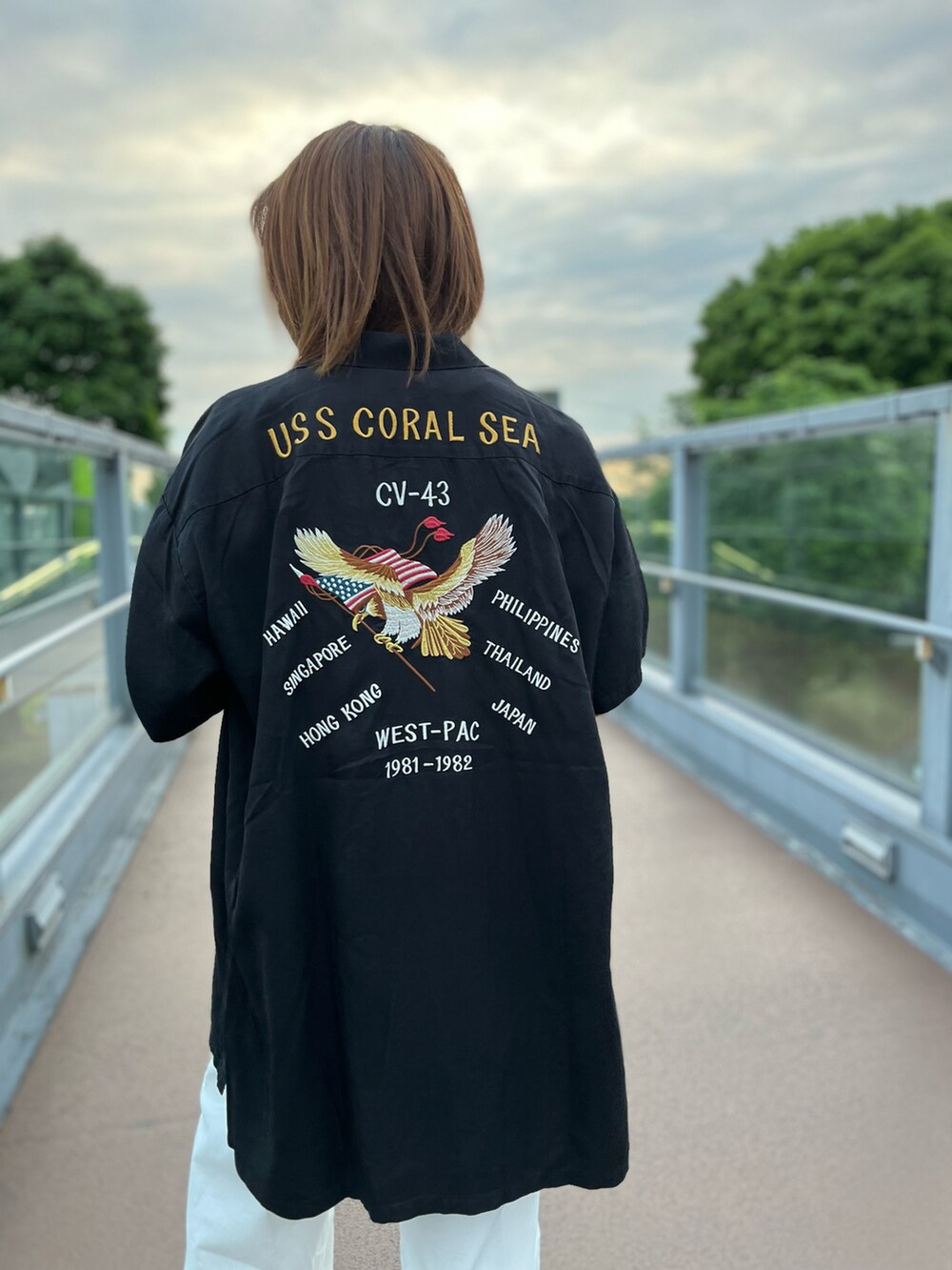 ブラック系のワンピース、ホワイト系のその他パンツを着用したレディースの春コーディネートの2枚目の写真