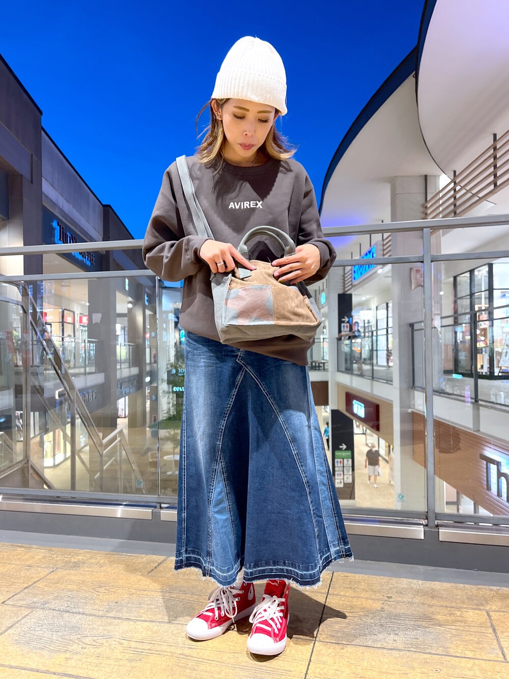 その他のデニムスカート、グレー系のスウェット、グリーン系のトートバッグを着用したレディースの秋コーディネートの2枚目の写真