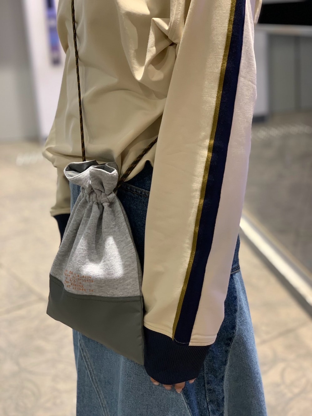 ベージュ系のジャージ、グレー系のショルダーバッグ、その他のデニムスカートを着用したレディースの冬コーディネートの3枚目の写真