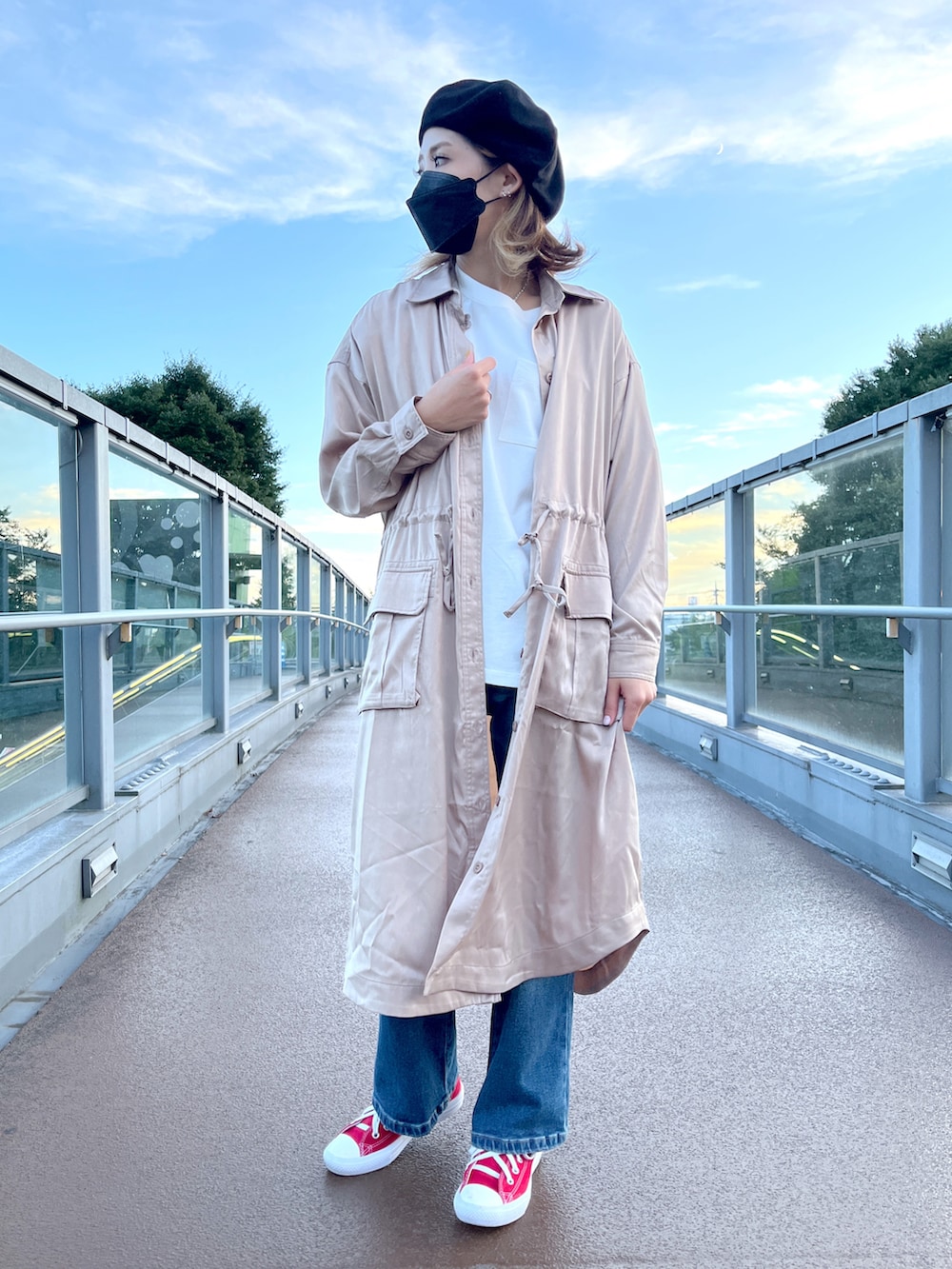 ベージュ系のシャツワンピース、ブルー系のデニムパンツ、ホワイト系のTシャツ/カットソーを着用したレディースの秋コーディネートの3枚目の写真