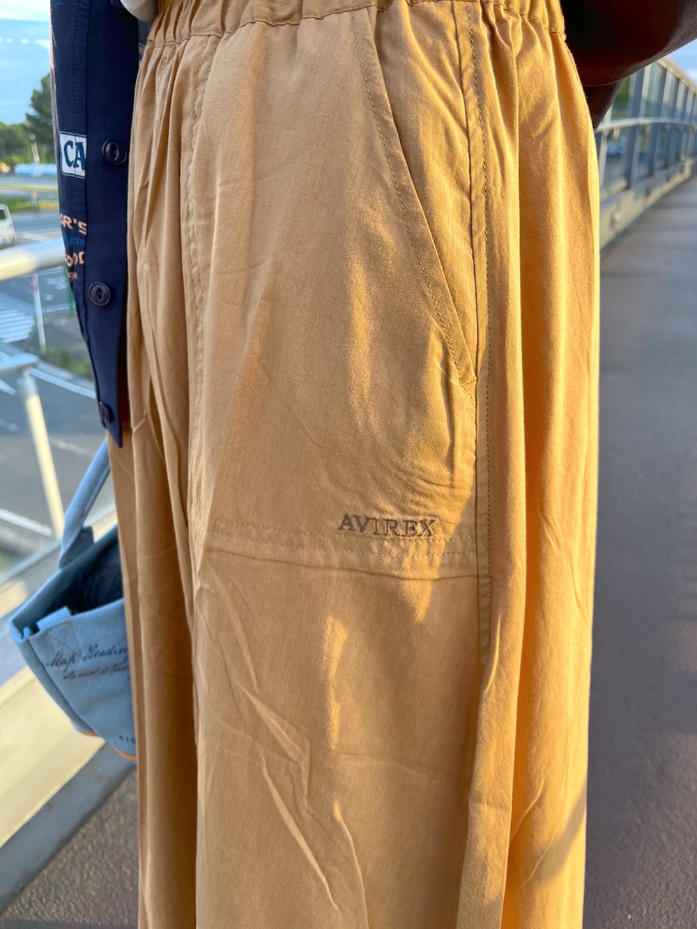 ホワイト系のTシャツ/カットソー、イエロー系のスカート、ブルー系のカーディガン/ボレロを着用したレディースの夏コーディネートの2枚目の写真