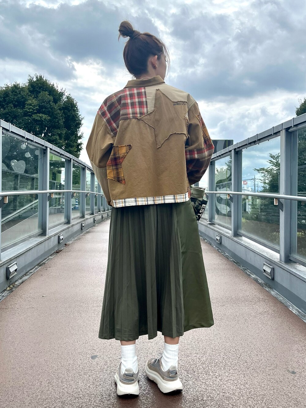 ベージュ系のその他アウター、グリーン系のスカート、ホワイト系のTシャツ/カットソーを着用したレディースの秋コーディネートの2枚目の写真