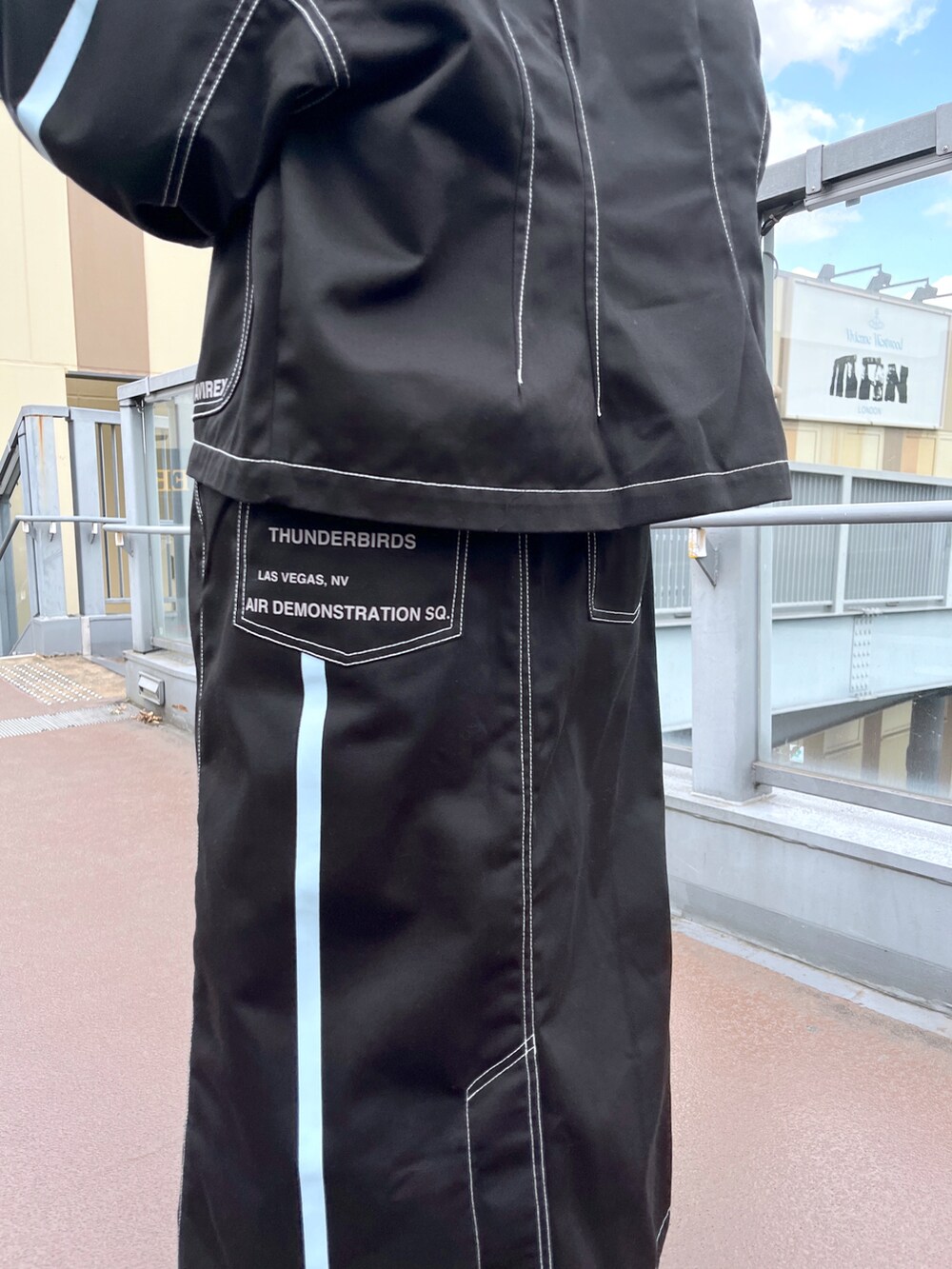 ブラック系のスカート、グレー系のショルダーバッグ、ブラック系のブルゾンを着用したレディースの夏コーディネートの4枚目の写真