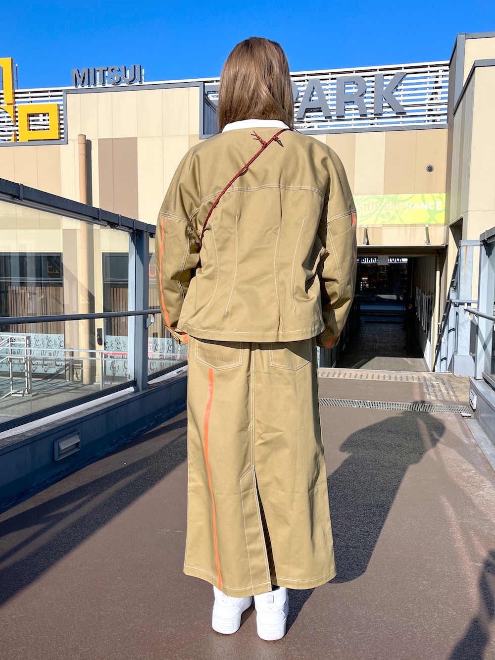 ベージュ系のスウェット、ブラウン系のブルゾン、ブラウン系のスカートを着用したレディースの冬コーディネートの3枚目の写真