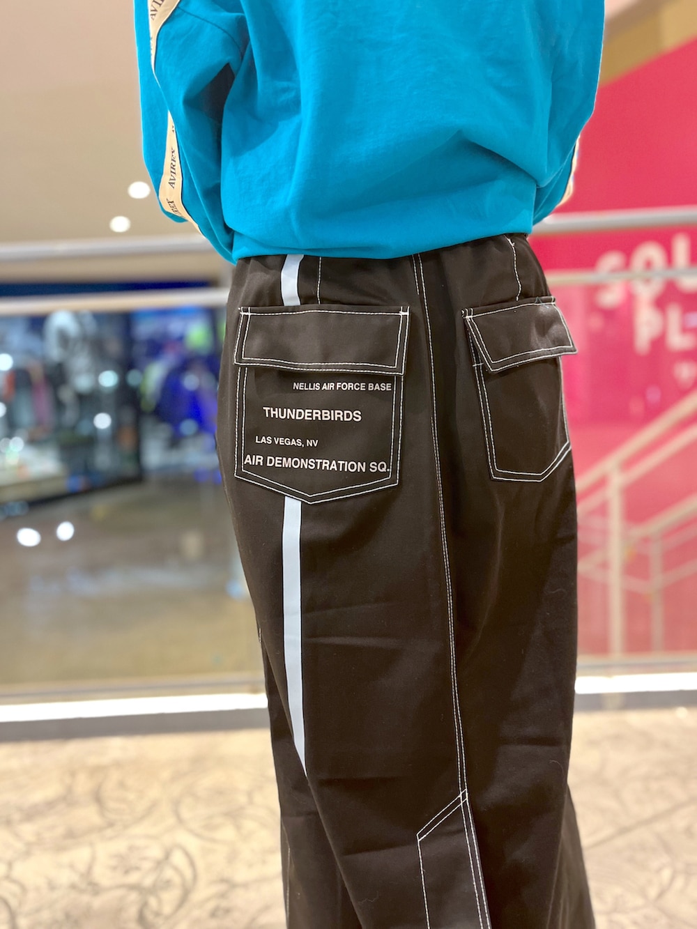 グリーン系のTシャツ/カットソー、ブラック系のスカート、グレー系のショルダーバッグを着用したレディースの冬コーディネートの4枚目の写真