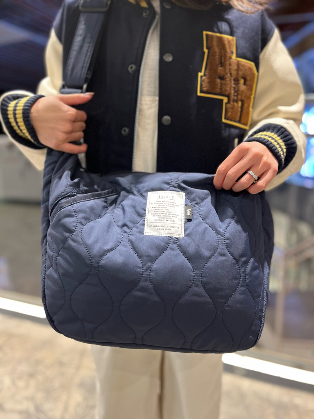 ホワイト系のサロペット/オーバーオール、ベージュ系のスウェット、ブルー系のショルダーバッグを着用したレディースの冬コーディネートの4枚目の写真