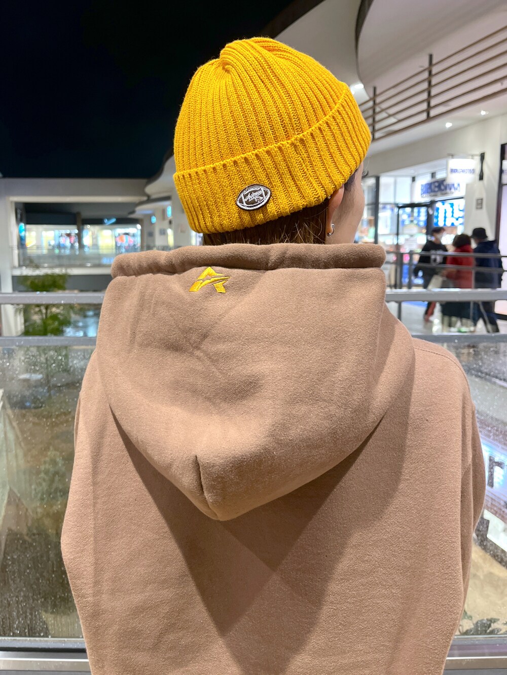 ブラウン系のパーカー、ブルー系のカーゴパンツ、イエロー系のニットキャップ/ビーニーを着用したレディースの秋コーディネートの4枚目の写真