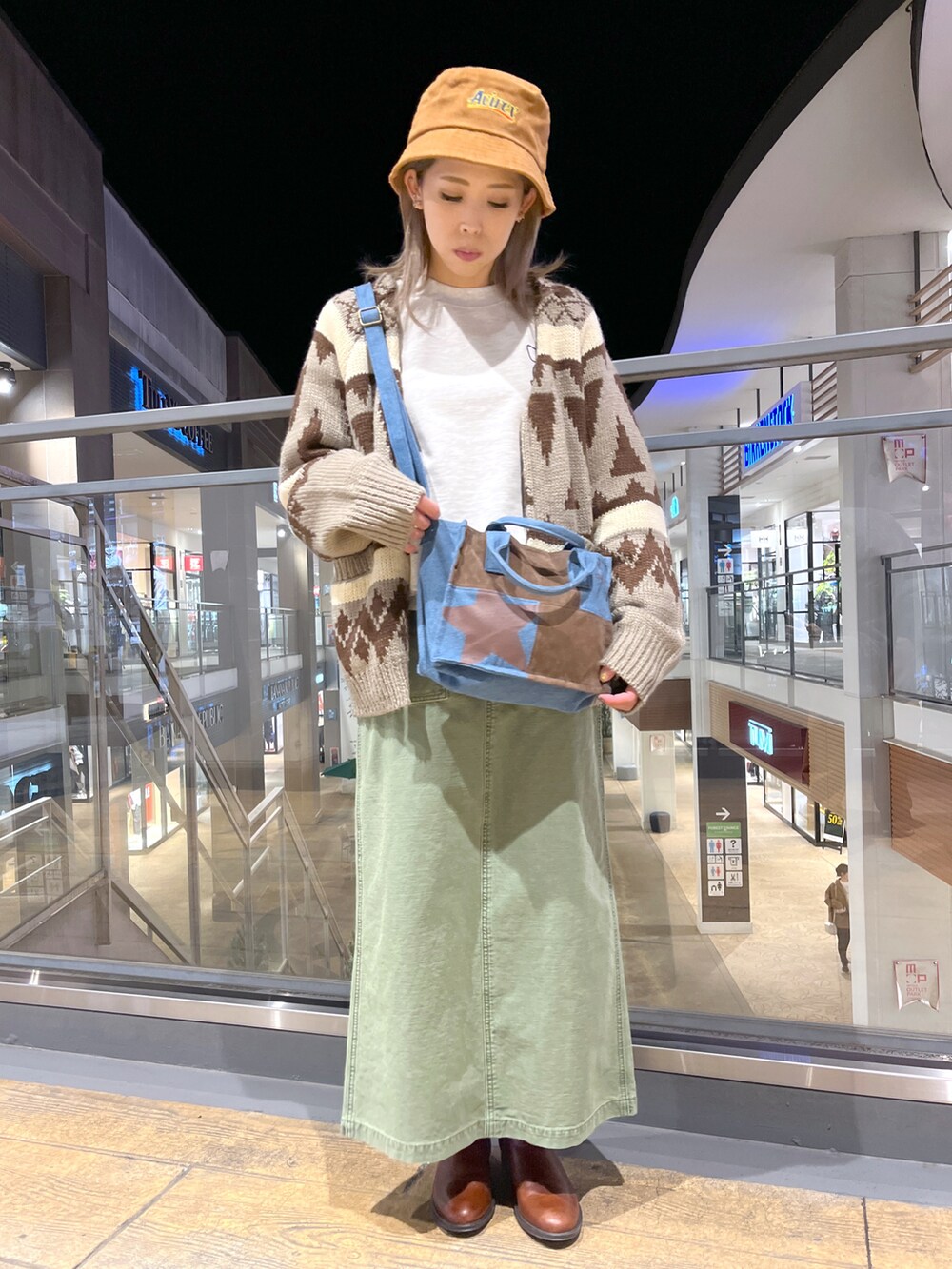 ベージュ系のスウェット、ブルー系のトートバッグ、ブラウン系のカーディガン/ボレロを着用したレディースの冬コーディネートの2枚目の写真