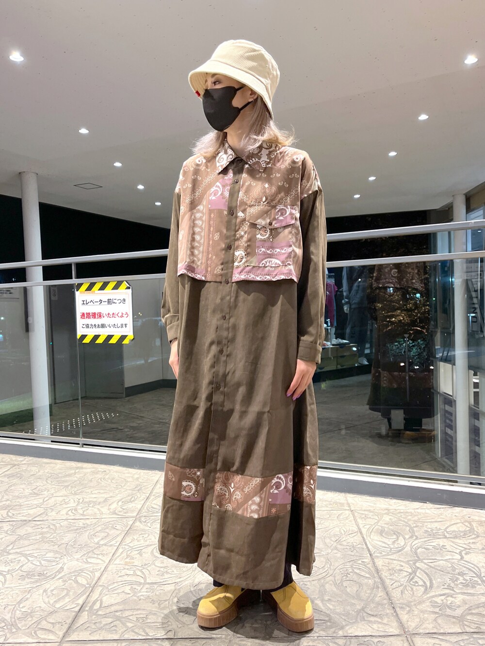 ブラック系のミリタリージャケット、ブラウン系のシャツワンピース、ブルー系のトートバッグを着用したレディースの秋コーディネートの5枚目の写真