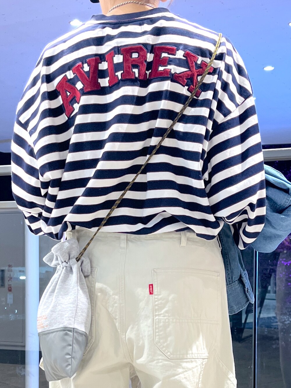 ブルー系のTシャツ/カットソー、ホワイト系のその他パンツ、グレー系のショルダーバッグを着用したレディースの春コーディネートの5枚目の写真